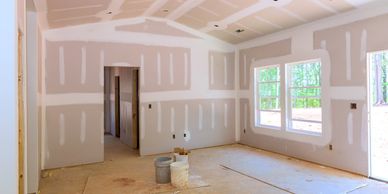 Room under construction with drywall installation in progress.