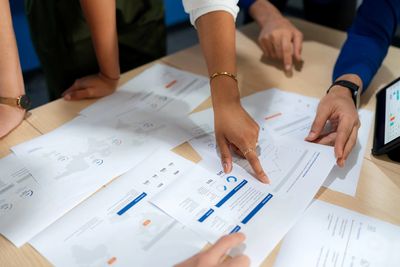 People collaborating with documents on a table.