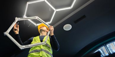 Worker installing a hexagonal light fixture.