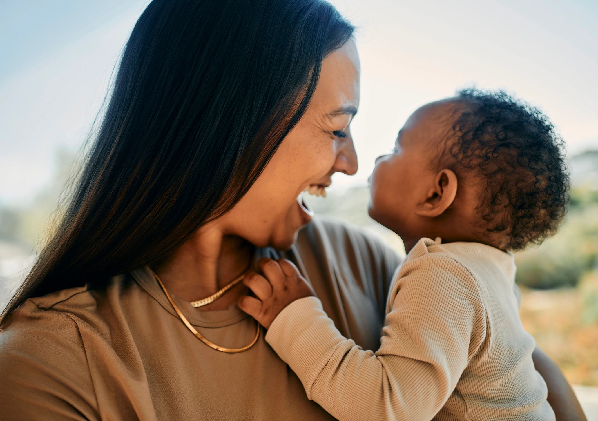 Mother lovingly holds baby, sharing a joyful moment.