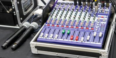 Audio mixer with two microphones on a table.