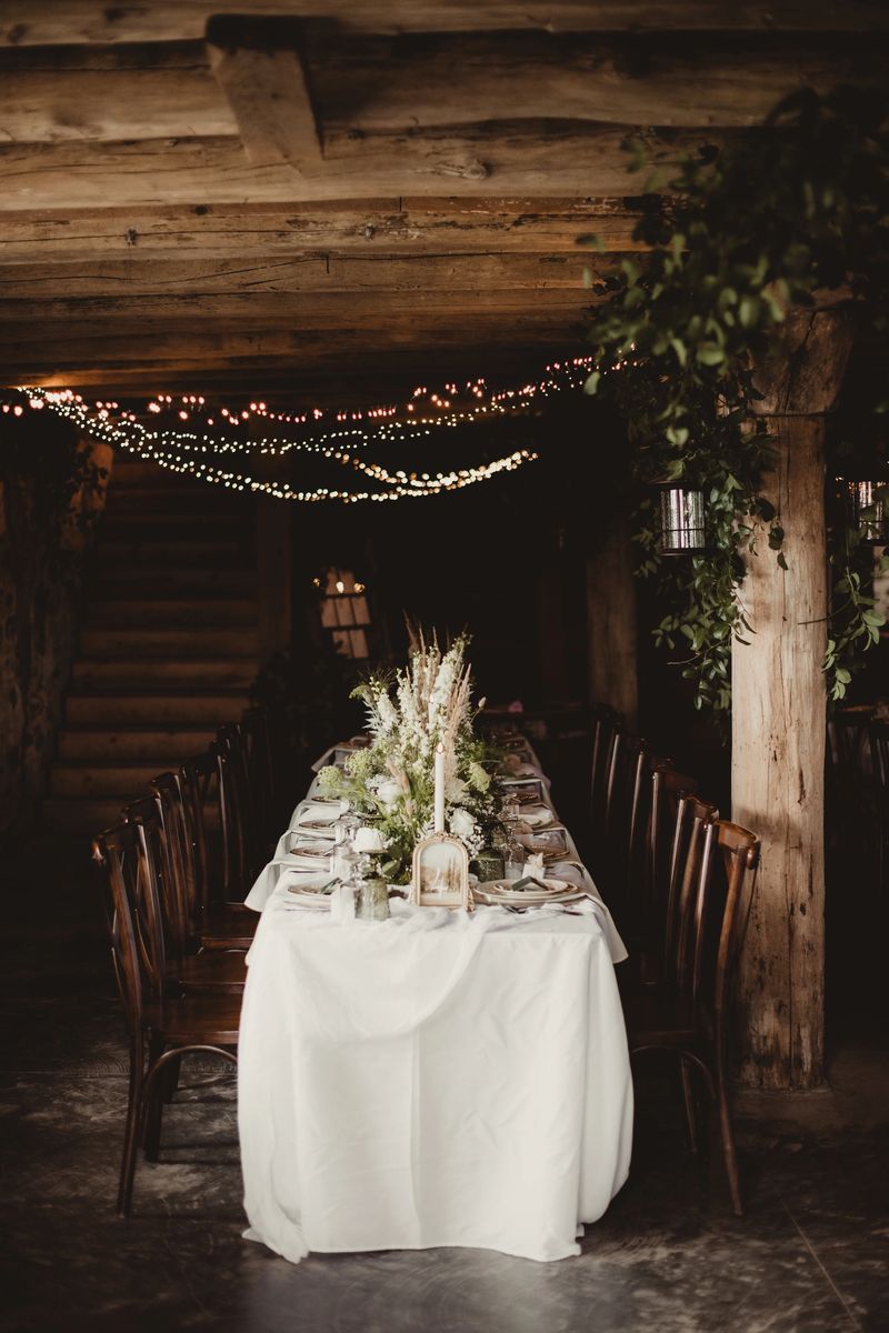 Long wedding reception dinner table in barn basement