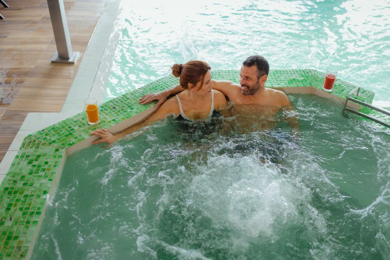 A Happy Couple Enjoys a Tranquil Moment Together in a hot tub at a High-end Spa Retreat. The Intimate and Cozy Setting Reflects Themes of Romance, Leisure, and Wellness