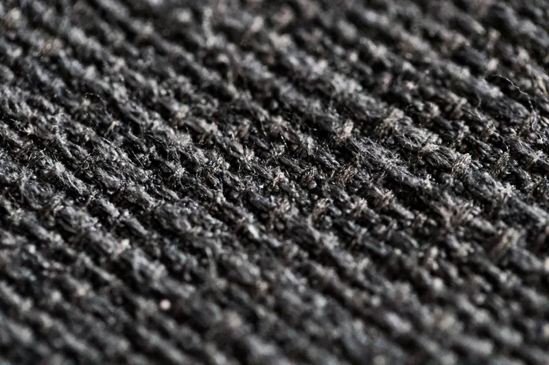 The fabric texture from the dark grey sofa is used for the background and texture design. High quality macro photo