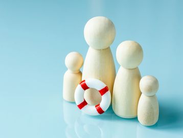 Wooden figurines representing a family with a life preserver symbolizing protection.