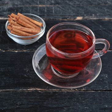 A cup of tea with cinnamon sticks.
