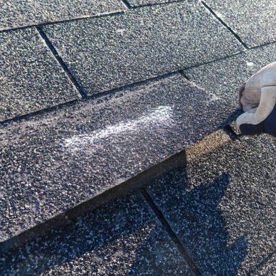 Chalk drawing of a bone on a roof shingle.