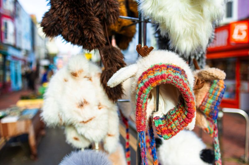 Close up color image depicting a selection of colorful woolly winter hats. The display is part of an outdoor market stall. Room for copy space.