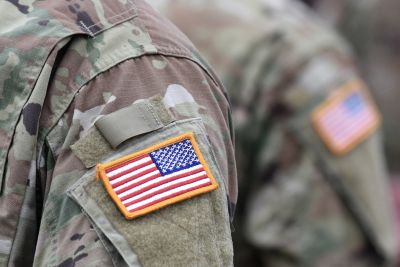 Close-up of American flag patches on soldiers' uniforms.