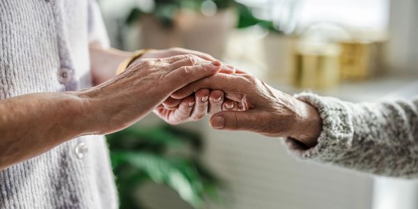 Two people holding hands in a comforting gesture.