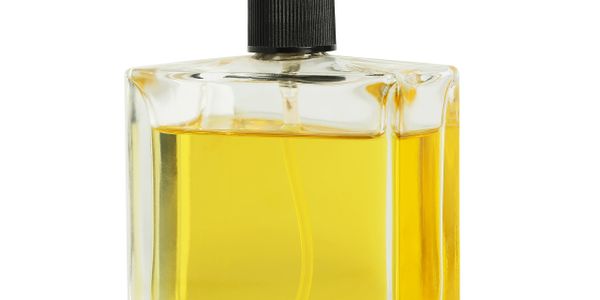 Square glass bottle filled with yellow liquid and black cap.