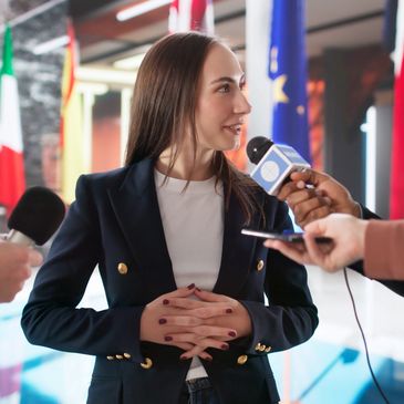     Female public relations executive speaking with members of the media during a professional press