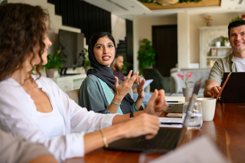 Diverse business professionals interacting and collaborating during a productive meeting inside a modern office space, discussing new strategies and ideas for their company
