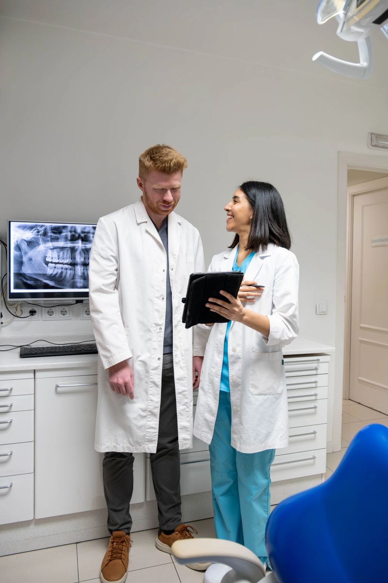 Two dentists collaborating in a modern dental office, reviewing a panoramic x-ray