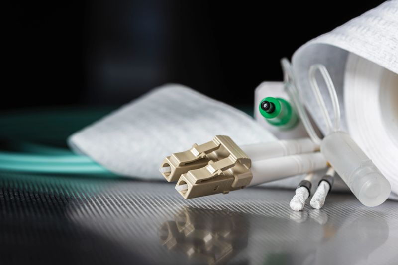 Fiber optic patch cords with accessories and tools used for cleaning fiber optic connectors. Technical equipment used in network infrastructure, telecommunications, and optical communication systems.