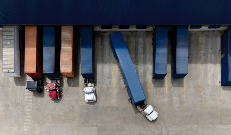 Aerial view of a truck leaving the loading dock at a distribution warehouse - freight transportation concepts