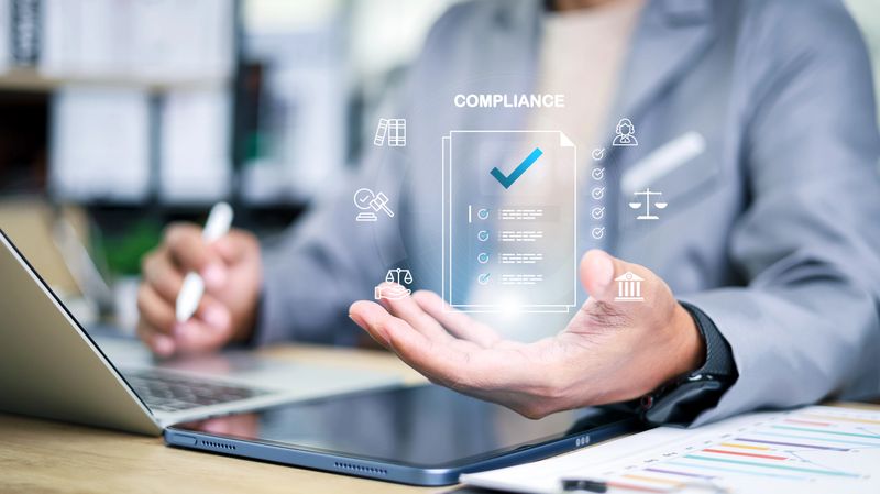 Business professional using digital tablet with virtual compliance checklist, legal and governance icons. Concept of corporate regulation, audit, risk management and digital transformation.