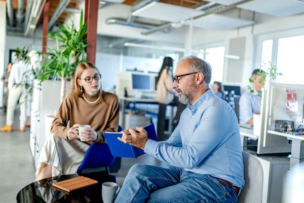 Colleagues discussing work in a modern office.
