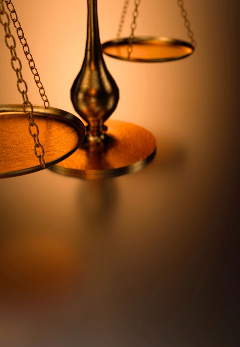 This close-up shot features an antique brass balance scale, highlighting its intricate details and warm, inviting glow against a softly blurred backdrop