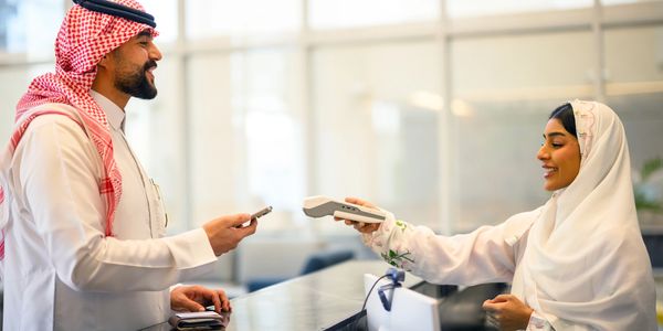 Man making payment at counter with woman.