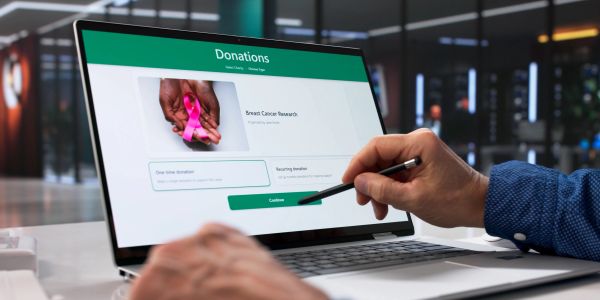 Person making an online donation for breast cancer research.