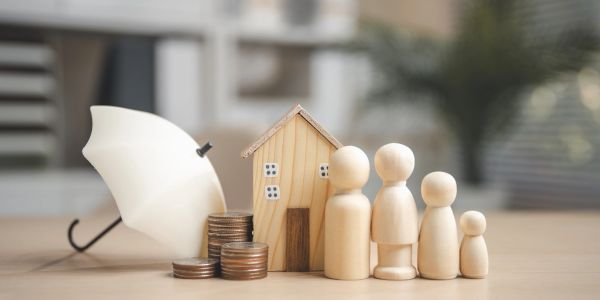 Wooden family figures with house, coins, and umbrella.