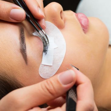 Eyelash extension application with tweezers.