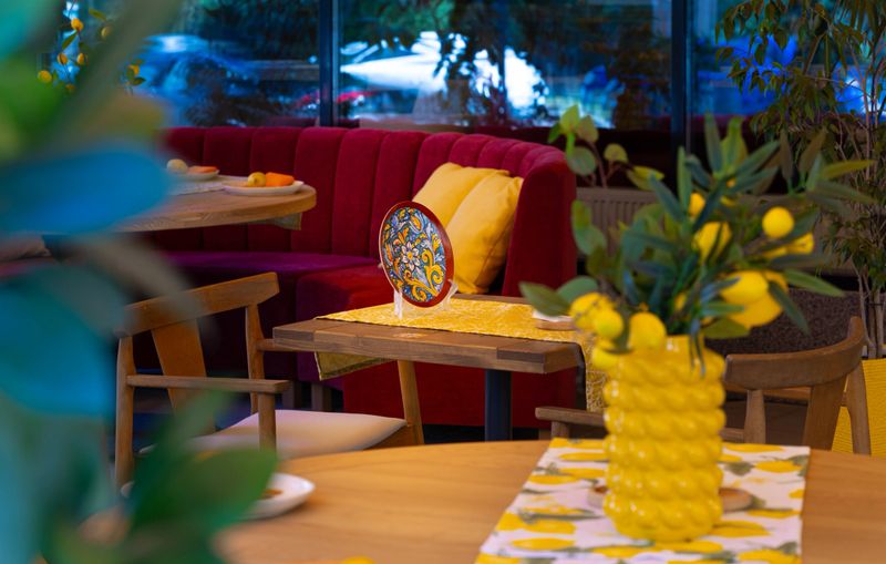 south aesthetic interior design restaurant furniture sitting place with objects cutlery decorative elements yellow color domination