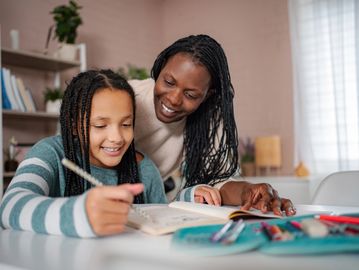 Mother helping daughter with homework.