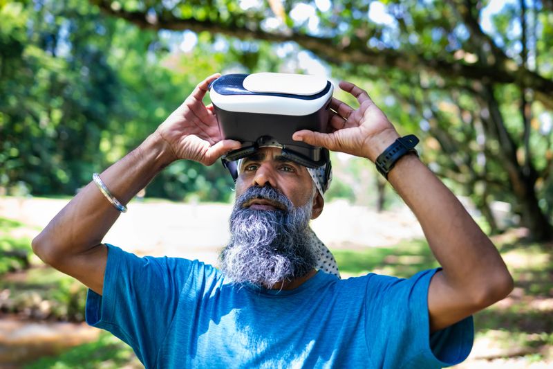 The senior Asian Sikh man in a turban discovers the wonders of nature through an engaging VR experience.