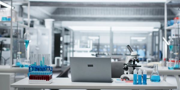 Modern laboratory workspace with scientific equipment and a laptop.