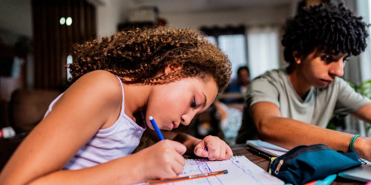 Two young students studying with focus at a table.