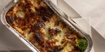 Un plat de lasagnes gratinées dans une barquette en aluminium.