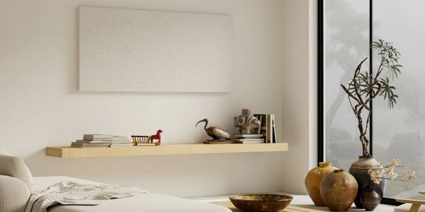 Minimalist living room with a floating shelf and decorative items.