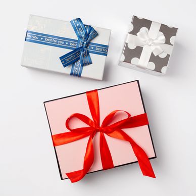 Three elegantly wrapped gift boxes with different ribbons and patterns.