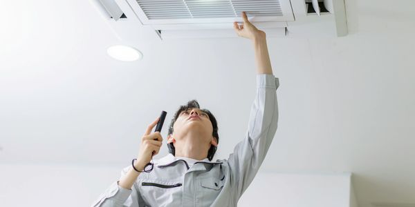 Person inspecting ceiling vent with a device.