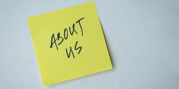 Yellow sticky note with 'ABOUT US' written on it.