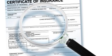 Certificate of insurance viewed through a magnifying glass.