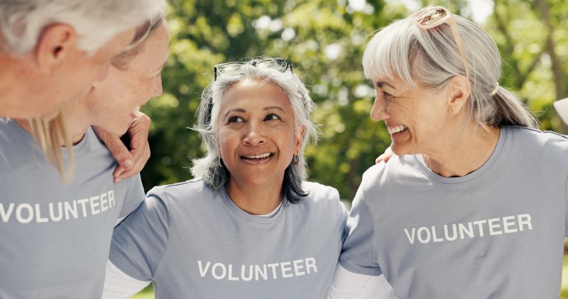 Old people, volunteer and huddle at park for community service, support and laugh together. Charity group, senior team and hug for collaboration, social responsibility and funny joke outdoor