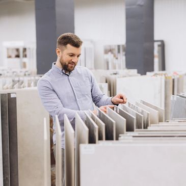 Man browsing tiles in a showroom.