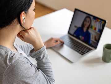 Woman attending a video call on a laptop.