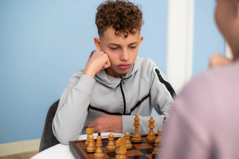 Teenager concentrating playing chess board game during competition