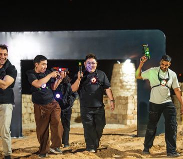 A girl holding a large red toy gun with a surprised expression.