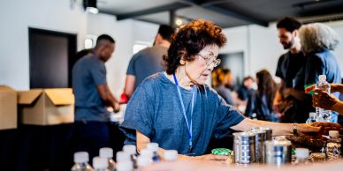 Volunteer sorting canned goods at a community event.
