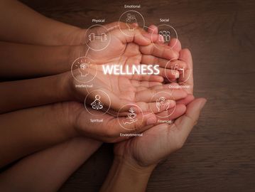 Hands holding wellness concept icons.