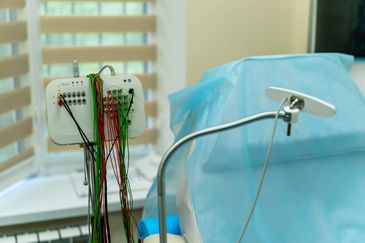 Medical device with wires near a patient bed.