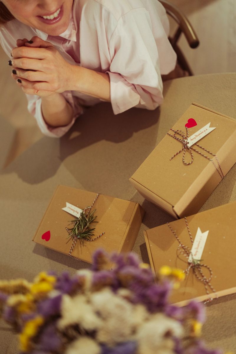 Female entrepreneur working at a table with packaged products in eco-friendly cardboard boxes. Small business lifestyle concept