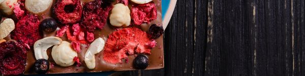 A close-up of mixed dried fruits and nuts on a wooden surface.