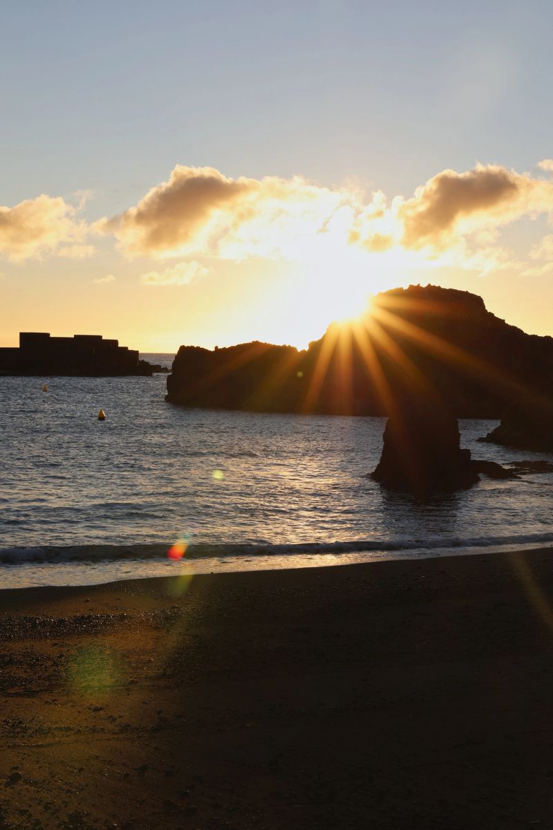 Spectacular morning sun at the coast of La Palma with dramatic lens flares and sunstar over the Atlantic.