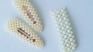 Three pearl-adorned hair clips on a white background.